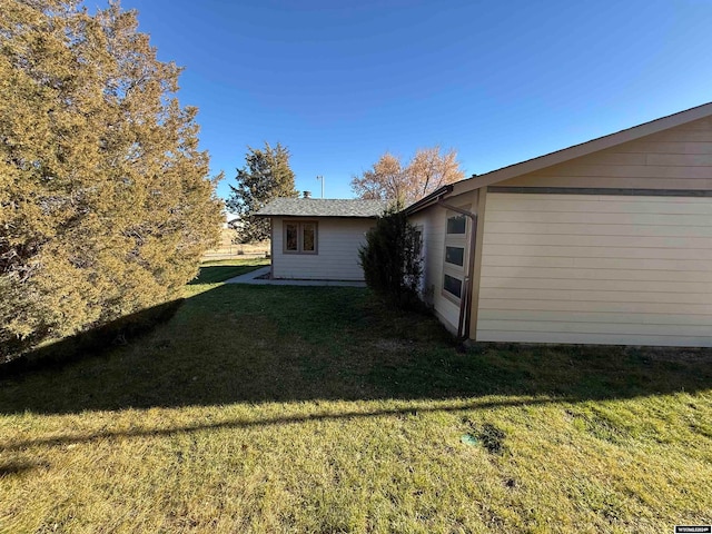 view of side of home with a yard