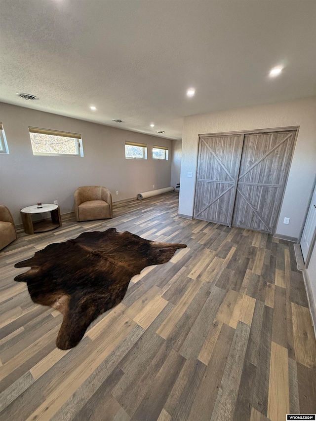 living room featuring wood-type flooring and a textured ceiling