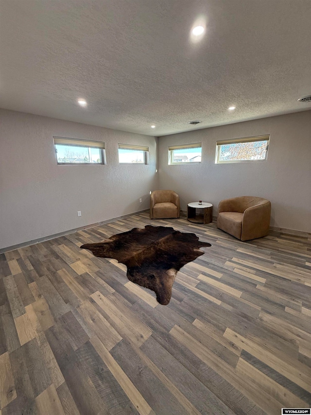 living area featuring hardwood / wood-style floors, a textured ceiling, and plenty of natural light