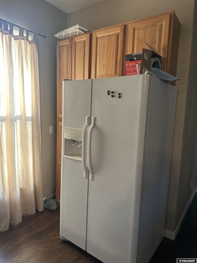 kitchen with dark wood-type flooring, brown cabinetry, and white refrigerator with ice dispenser
