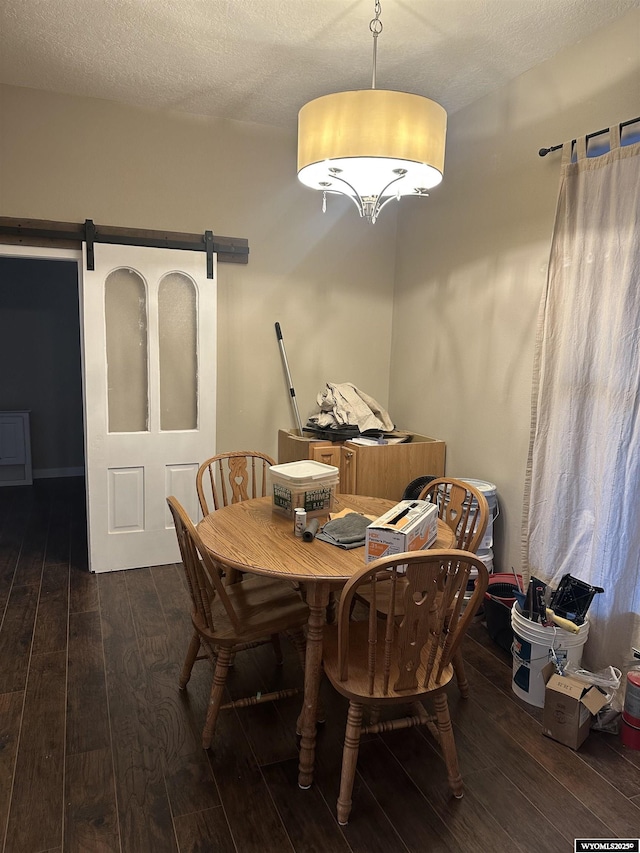 dining room with hardwood / wood-style floors, a textured ceiling, and a barn door