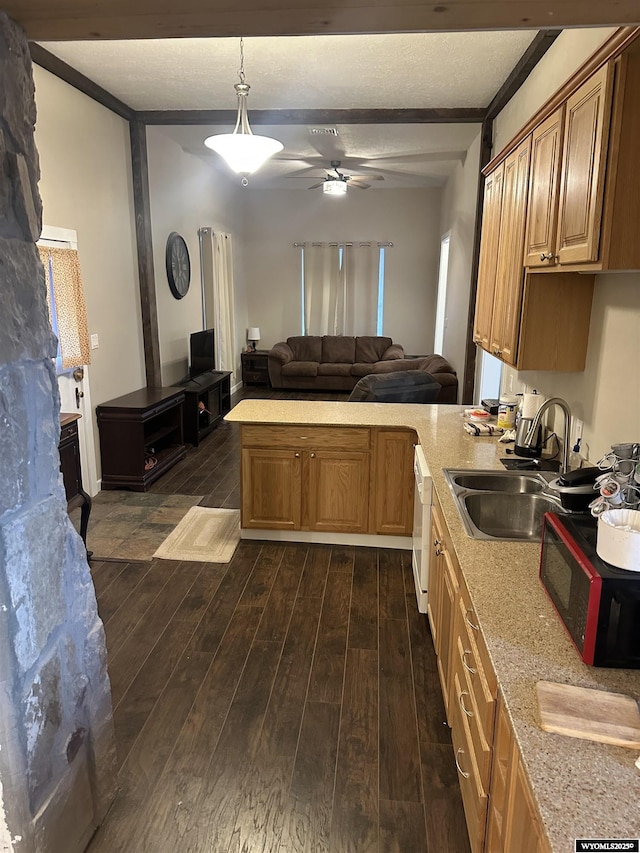 kitchen with dark wood-style flooring, light countertops, a sink, open floor plan, and beam ceiling
