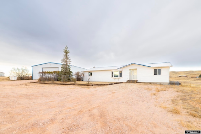 view of front of house with a garage and an outdoor structure