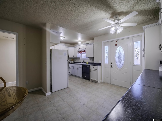 909 Skyline Dr, Douglas, WY 82633 - kitchen with freestanding refrigerator, black dishwasher, dark countertops, a textured ceiling, and a ceiling fan