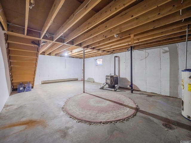 basement with a wood stove, water heater, and a baseboard heating unit