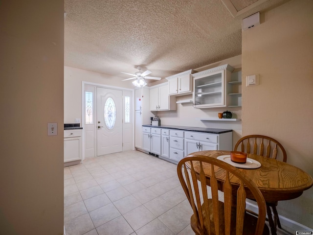 kitchen with a ceiling fan, open shelves, white cabinets, a textured ceiling, and dark countertops