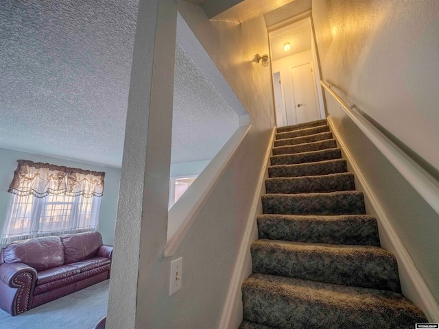 stairs with carpet flooring and a textured ceiling