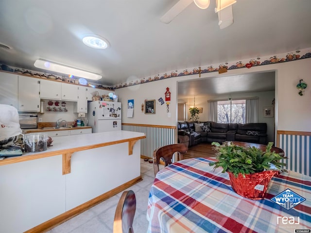 dining area with ceiling fan and sink