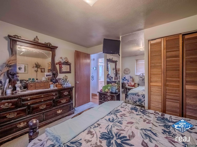 bedroom with a textured ceiling, light carpet, and a closet