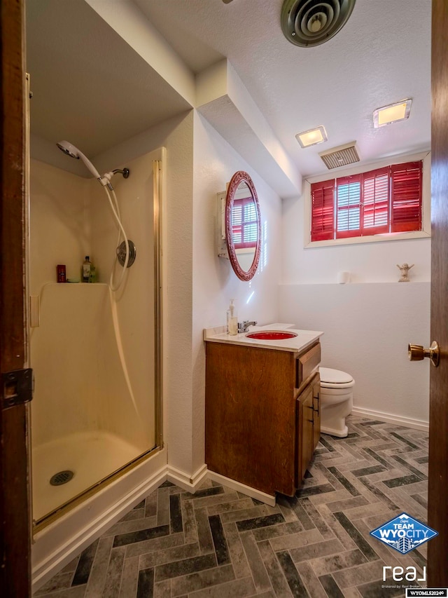 bathroom featuring vanity, toilet, and an enclosed shower