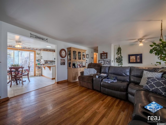 living room featuring ceiling fan and light hardwood / wood-style floors