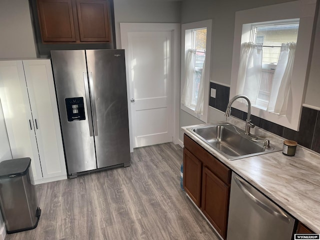 kitchen featuring light wood-type flooring, sink, and appliances with stainless steel finishes