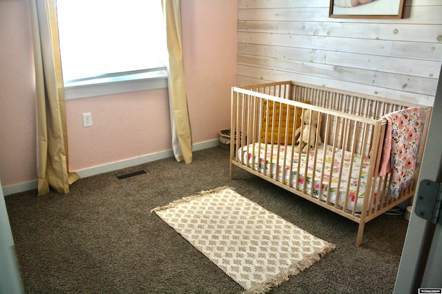 carpeted bedroom featuring a nursery area