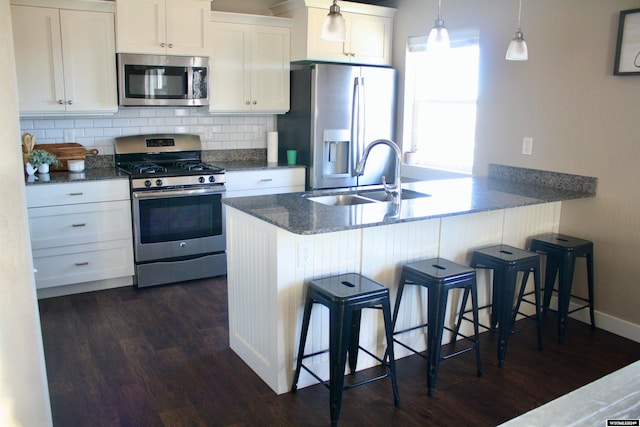 kitchen featuring white cabinets, a breakfast bar, and stainless steel appliances