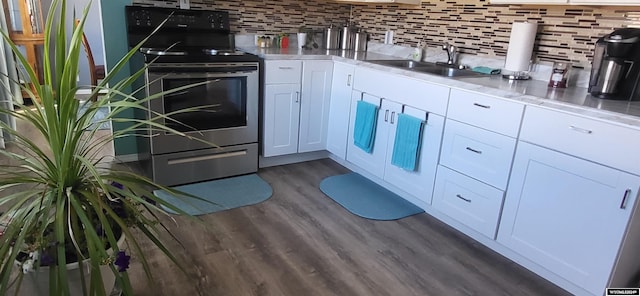 kitchen with backsplash, dark wood-type flooring, white cabinets, sink, and electric range