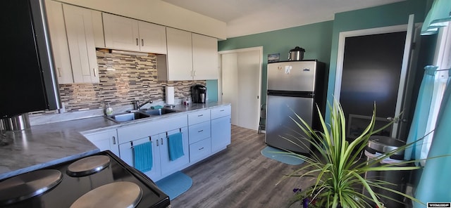 kitchen featuring stainless steel fridge, backsplash, hardwood / wood-style flooring, range, and white cabinetry