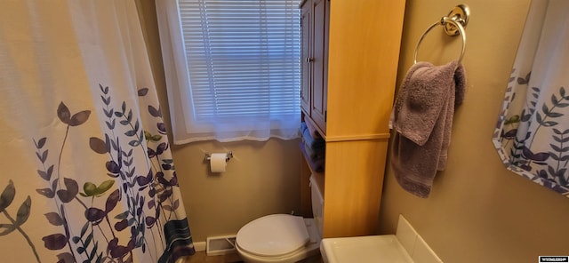 bathroom featuring curtained shower and toilet