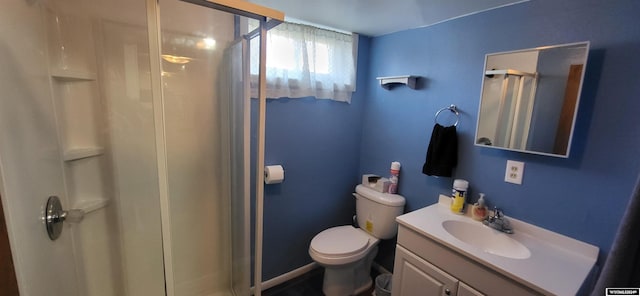 bathroom featuring vanity, toilet, and a shower with door