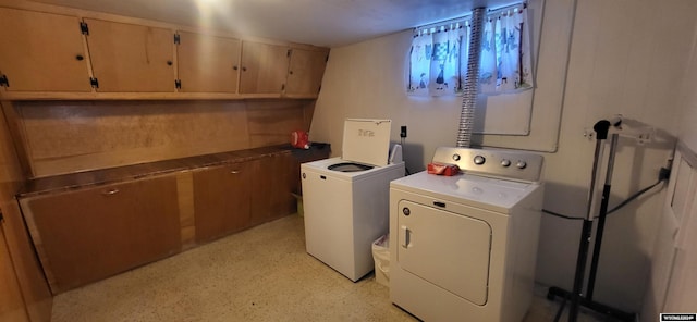 washroom featuring washer and clothes dryer and cabinets