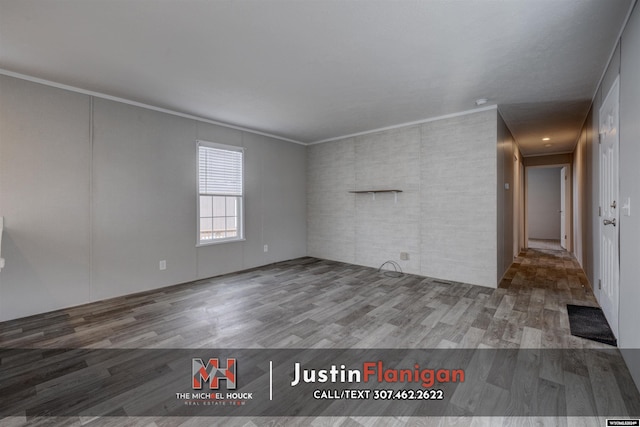 empty room featuring wood-type flooring and ornamental molding