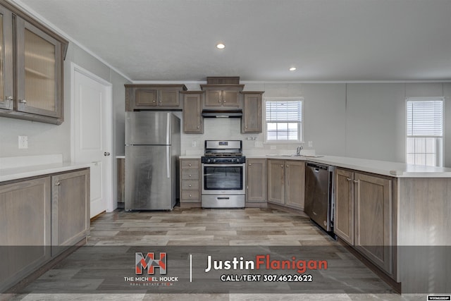 kitchen featuring backsplash, light wood-type flooring, ornamental molding, and appliances with stainless steel finishes