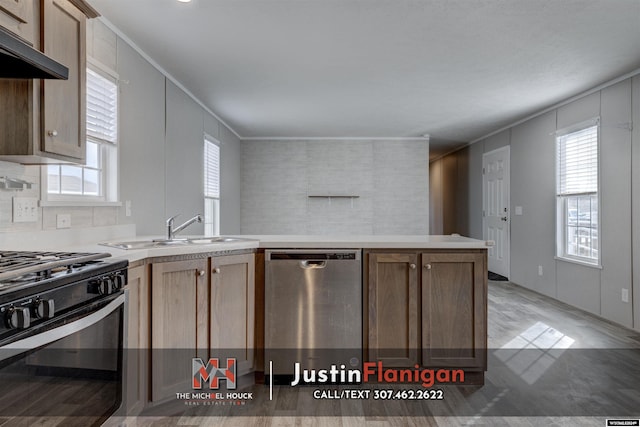 kitchen with sink, stainless steel dishwasher, crown molding, black range with gas cooktop, and wood-type flooring