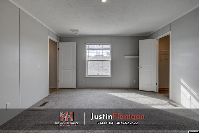 carpeted empty room with a textured ceiling