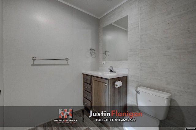 bathroom featuring hardwood / wood-style floors, vanity, toilet, and crown molding