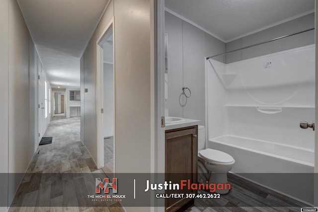 full bathroom with shower / bath combination, wood-type flooring, a textured ceiling, toilet, and vanity