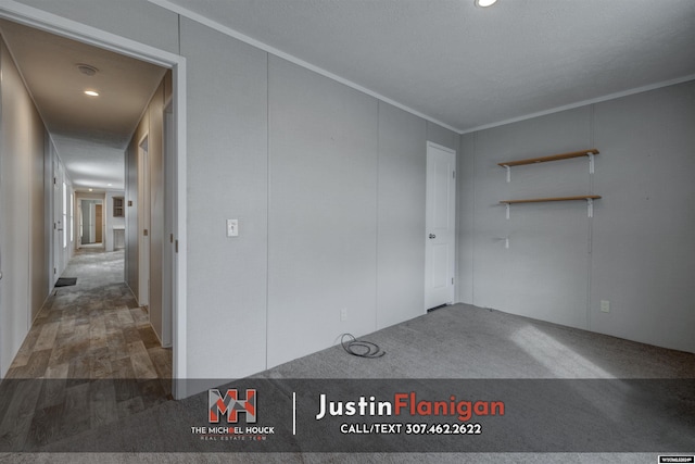 spare room featuring wood-type flooring, a textured ceiling, and ornamental molding