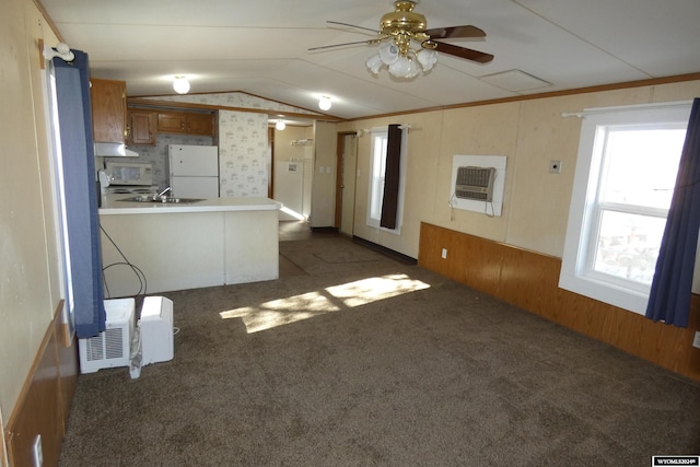 unfurnished living room with heating unit, ceiling fan, dark colored carpet, lofted ceiling, and wood walls