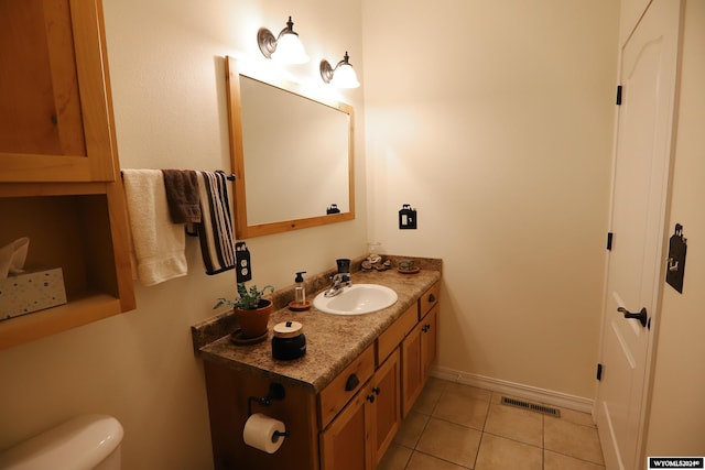 bathroom featuring tile patterned flooring, vanity, and toilet