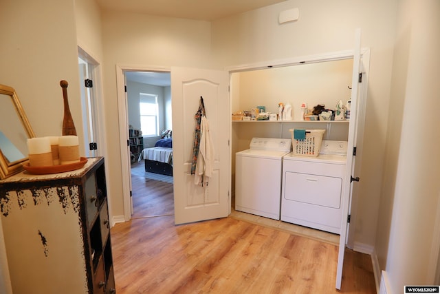 washroom featuring washer and clothes dryer and light hardwood / wood-style floors