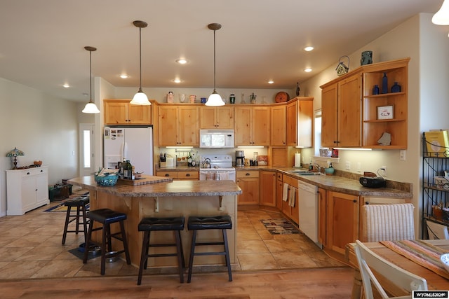 kitchen with light hardwood / wood-style flooring, a kitchen island, decorative light fixtures, and white appliances