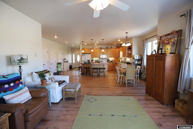 living room featuring dark hardwood / wood-style flooring and ceiling fan with notable chandelier