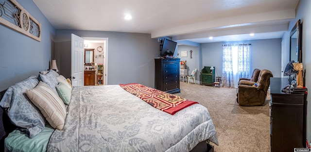 carpeted bedroom with beam ceiling and ensuite bathroom