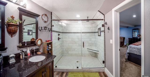 bathroom with a shower with door, vanity, and a textured ceiling