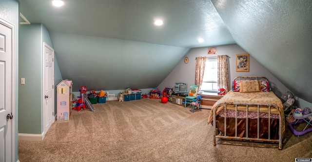 bedroom with carpet, a textured ceiling, and vaulted ceiling