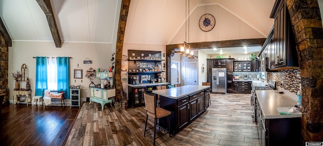 kitchen featuring stainless steel fridge, dark brown cabinets, decorative light fixtures, hardwood / wood-style floors, and a center island