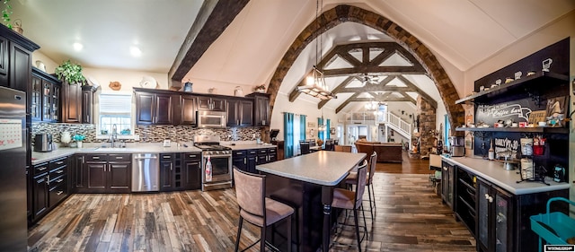 kitchen with hardwood / wood-style flooring, dark brown cabinetry, appliances with stainless steel finishes, and tasteful backsplash