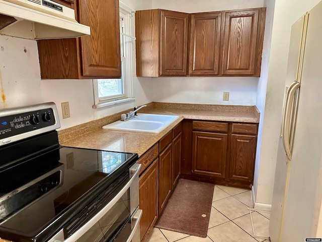 kitchen featuring stainless steel electric stove, sink, light tile patterned flooring, and white refrigerator