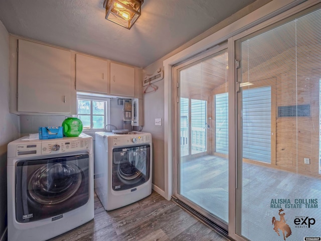 laundry area with hardwood / wood-style floors, cabinets, and separate washer and dryer