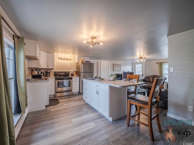 kitchen with white cabinetry, plenty of natural light, light hardwood / wood-style flooring, and appliances with stainless steel finishes