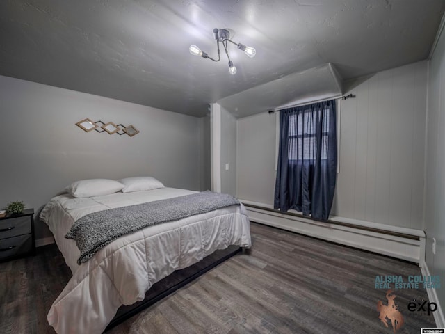 bedroom with baseboard heating, wood walls, and wood-type flooring