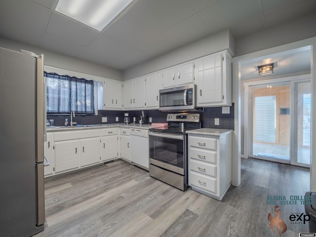 kitchen with white cabinets, a healthy amount of sunlight, backsplash, and appliances with stainless steel finishes