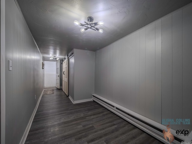 hall with baseboard heating, dark wood-type flooring, and wood walls