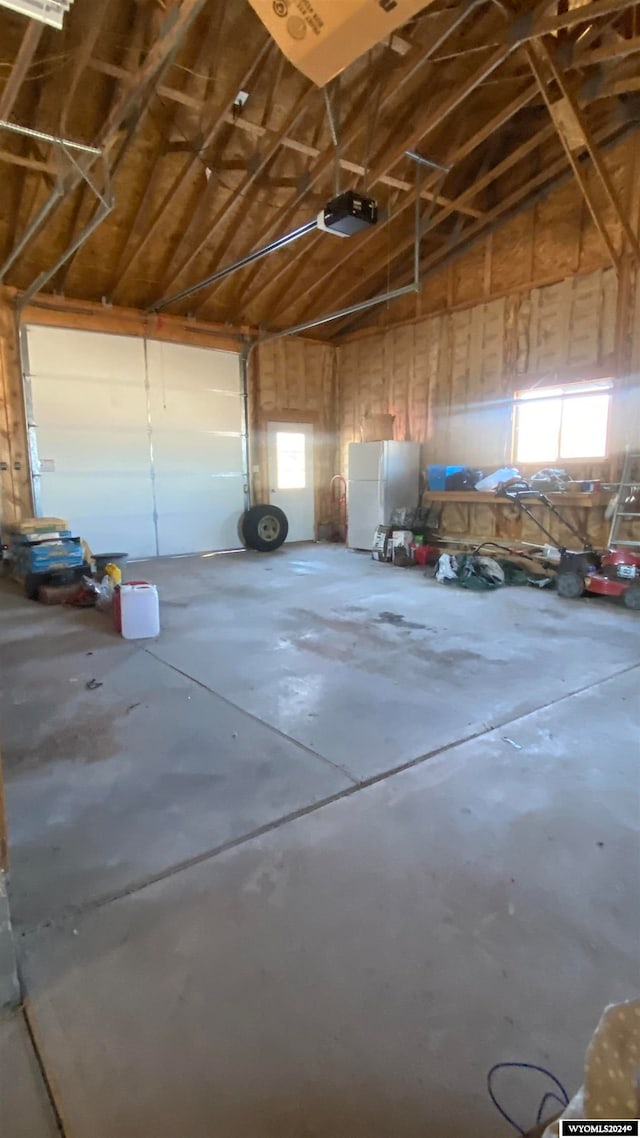 garage with white fridge and a garage door opener