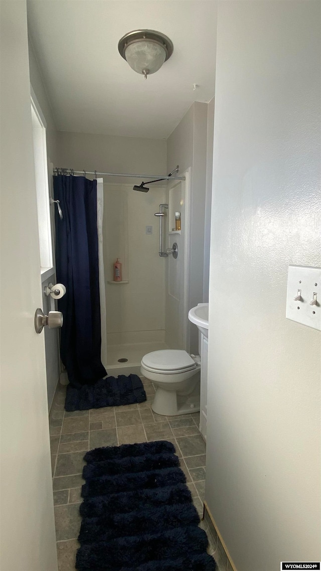 bathroom featuring tile patterned floors, a shower with curtain, and toilet