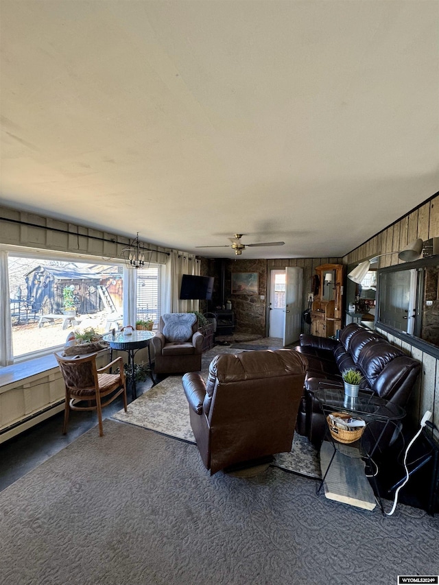 carpeted living room featuring ceiling fan with notable chandelier