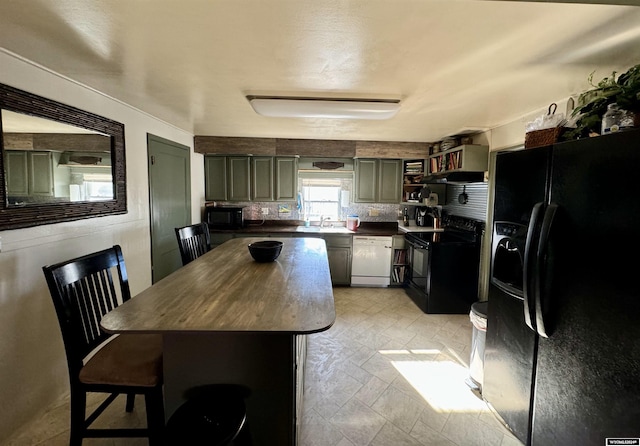 kitchen with a center island, black appliances, sink, decorative backsplash, and a breakfast bar area